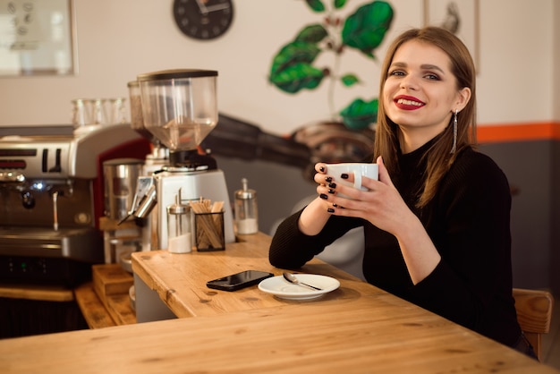 Retrato de jovem bebendo café no café.