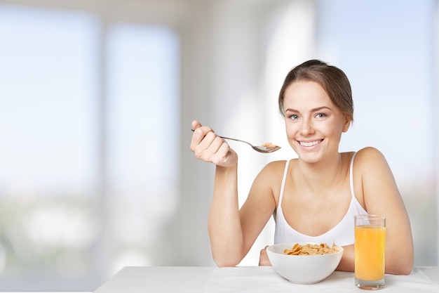 Retrato de jovem bonita com comida no fundo da cozinha