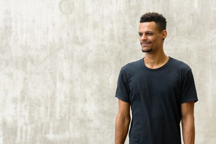 Foto retrato de jovem bonito barbudo africano contra uma parede de concreto ao ar livre