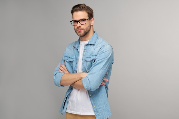 Retrato de jovem bonito com camisa jeans sobre parede de luz