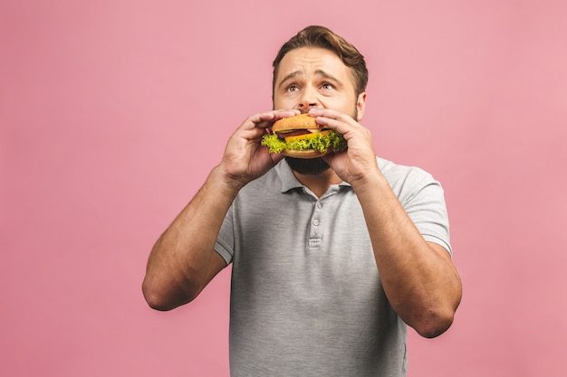 Retrato de jovem bonito comendo hambúrguer