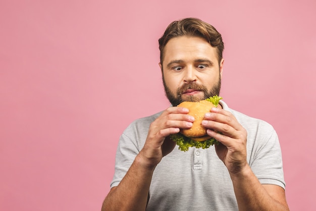 Retrato de jovem bonito comendo hambúrguer