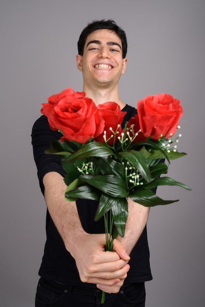 Retrato de jovem bonito contra cinza