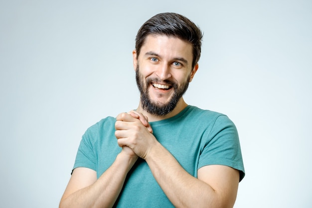 Retrato de jovem bonito e positivo isolado em um fundo cinza