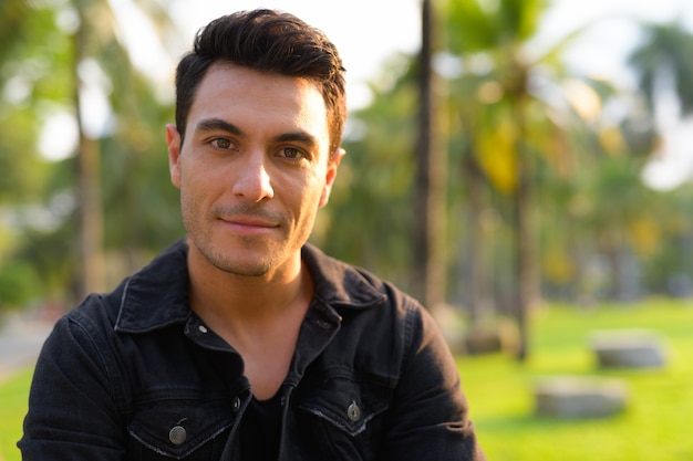 Foto retrato de jovem bonito hispânico no parque ao ar livre