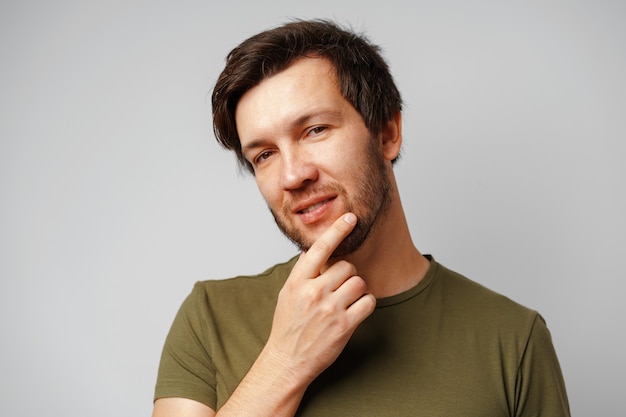 Retrato de jovem bonito sorrindo contra um fundo cinza