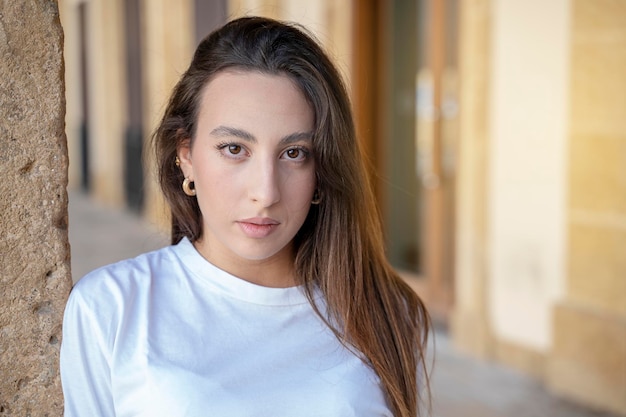 Retrato de jovem cabelo castanho estilo de cabelo elegante mulher caucasiana mulher posando ao ar livre na cidade, olhando para a câmera