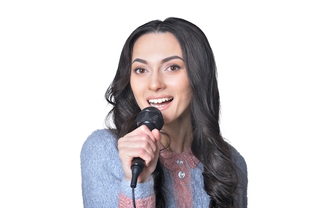 Retrato de jovem cantando com microfone no fundo branco