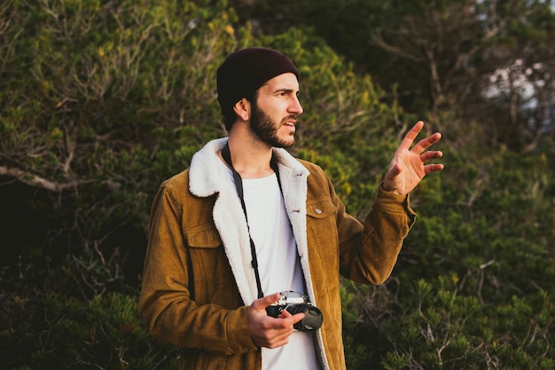 Foto retrato de jovem carregando uma câmera ao ar livre