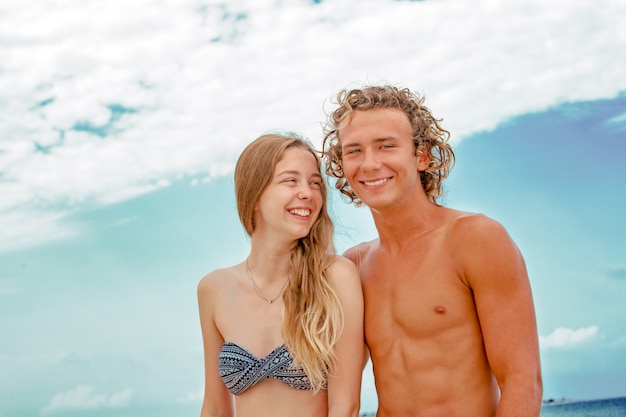 Retrato de jovem casal apaixonado na praia e aproveitando o tempo juntos. Casal jovem se divertindo em uma costa arenosa.