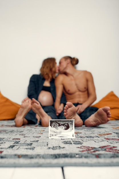 Retrato de jovem casal feliz segura imagem de ultra-som família alegre e foto de ultra-som conceito de gravidez cuidados de saúde ginecologia mãe esperando bebê