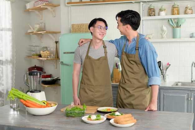 Retrato de jovem casal gay sorridente na cozinha em casa LGBTQ e conceito de diversidade