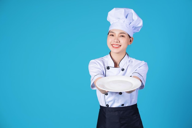 Retrato de jovem chef feminino asiático em segundo plano