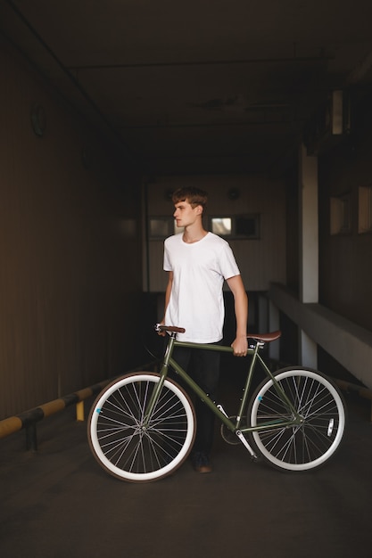 Retrato de jovem com cabelo castanho em pé de bicicleta