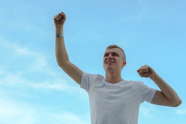 Retrato de jovem com cabelo loiro contra a vista do céu claro ao ar livre