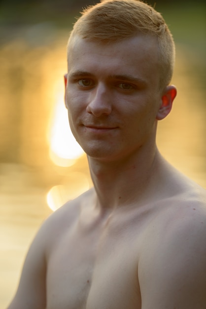 Foto retrato de jovem com cabelo loiro sem camisa no parque ao ar livre