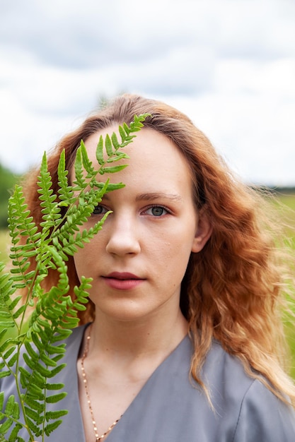 Retrato de jovem com folha de samambaia verde