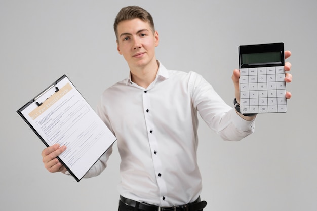 Retrato de jovem com forma de pagamento de contas e calculadora nas mãos dele isolado no branco