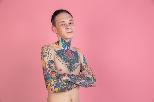 Retrato de jovem com tatuagem na parede rosa