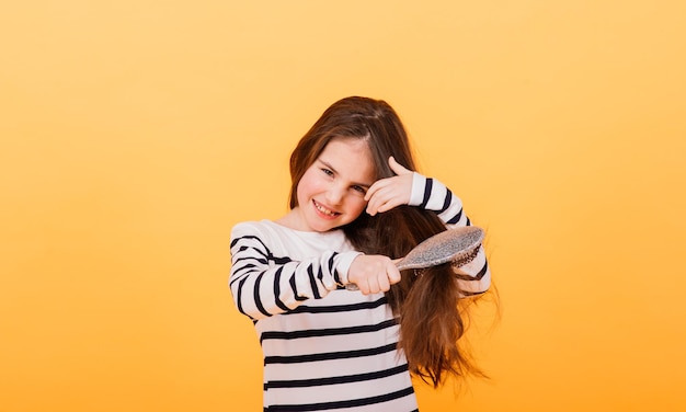 Retrato de jovem com um problema de perda de cabelo careca. Tiro na cabeça da menina nervosa com uma escova de cabelo.