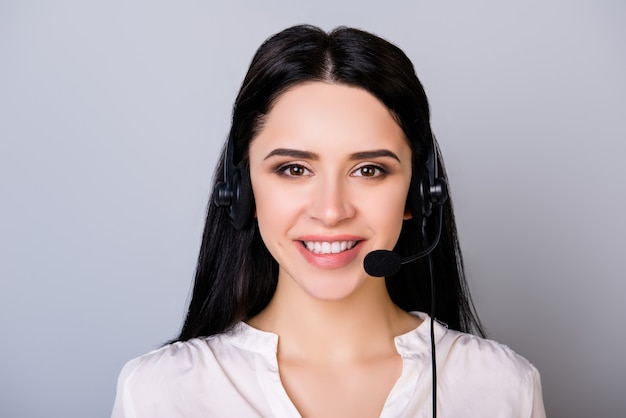 Retrato de jovem consultor de call center em fones de ouvido isolados no espaço cinza