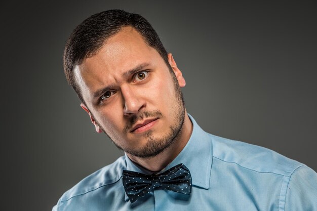 Retrato de jovem de camisa azul olhando com desconfiança