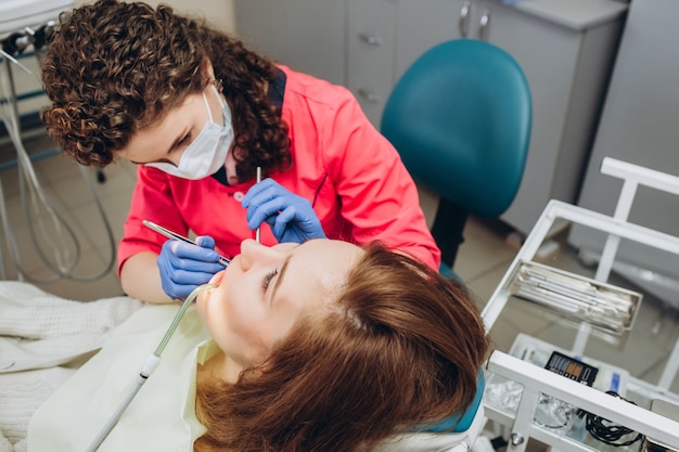 Retrato de jovem dentista feminina na clínica odontológica