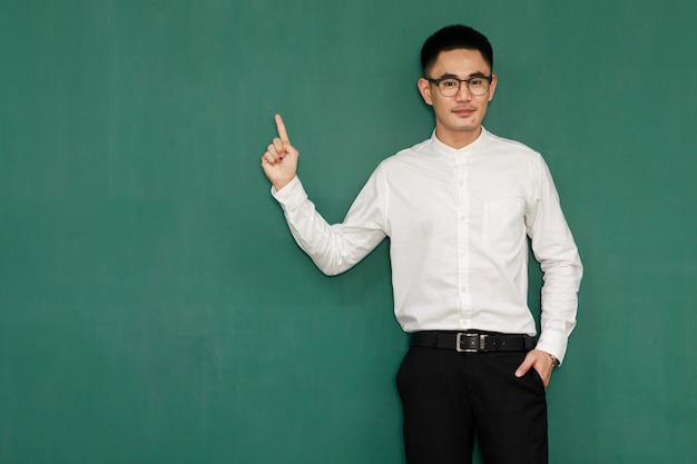 Retrato de jovem e bonito homem asiático, usando óculos e roupas de negócios casuais, camisa branca e calça preta, posar em gestos de publicidade e apresentar algumas coisas com autoconfiança.