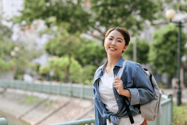 Retrato de jovem elegante caminhando na rua, vestindo uma roupa da moda fofa, sorrindo, curtindo seus fins de semana, viajar com uma mochila