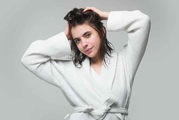 Retrato de jovem em modelo feminino de roupão de manhã com rotina matinal de beleza de cabelo molhado