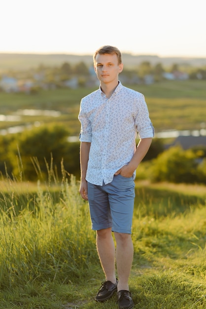 Retrato de jovem em pé ao ar livre durante um dia ensolarado de verão