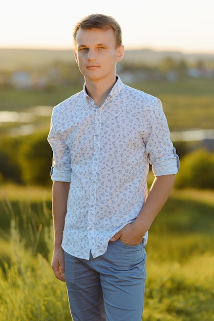 Retrato de jovem em pé ao ar livre durante um dia ensolarado de verão