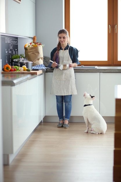 Foto retrato de jovem em pé contra o fundo da cozinha