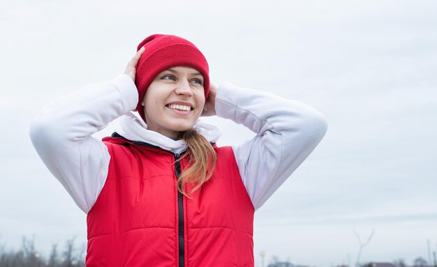 Foto retrato de jovem em roupas esportivas vermelhas e brancas brilhantes ao ar livre