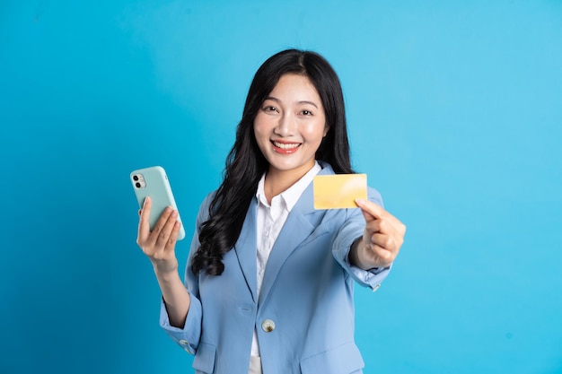 Retrato de jovem empresária asiática posando em fundo azul