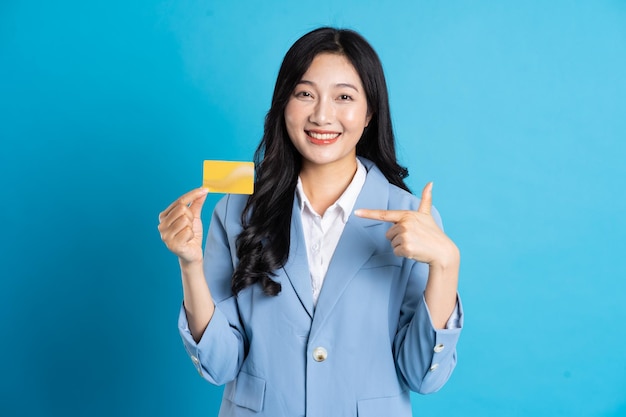 Retrato de jovem empresária asiática posando em fundo azul