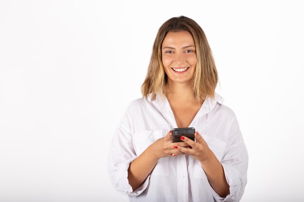 Foto retrato de jovem empresária com smartphone em estúdio