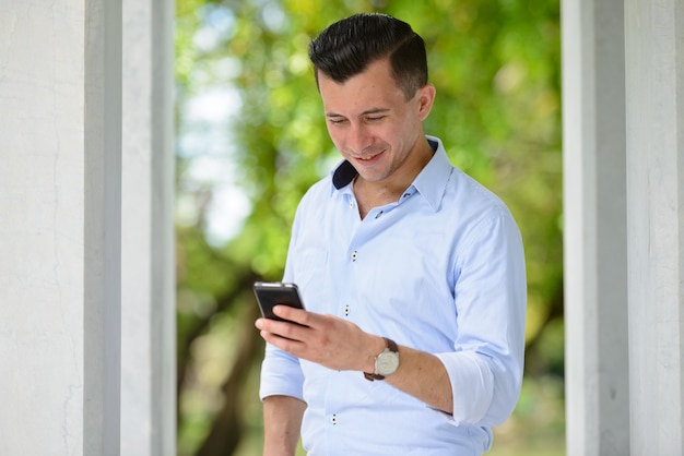 Retrato de jovem empresário bonito no parque da cidade