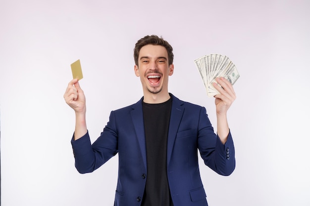 Retrato de jovem empresário bonito sorridente mostrando cartão de crédito e dinheiro isolado sobre fundo branco