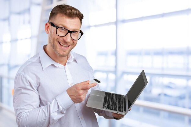 Retrato de jovem empresário com laptop