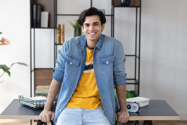 Retrato de jovem empresário de sucesso confiante em roupas casuais no local de trabalho. Empreendedor está no escritório