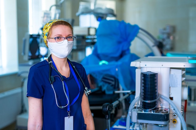 Retrato de jovem enfermeira cirúrgica em jaleco em pé na sala de cirurgia Retrato de médica na sala médica moderna