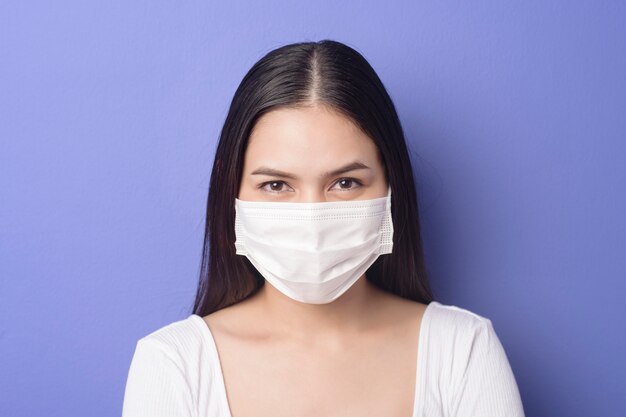 Retrato de jovem está usando máscara facial em fundo roxo