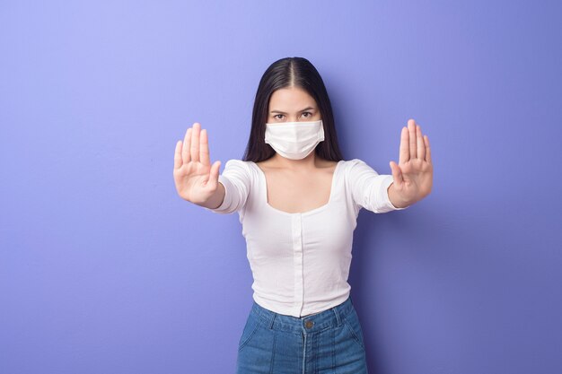 Retrato de jovem está usando máscara facial em fundo roxo