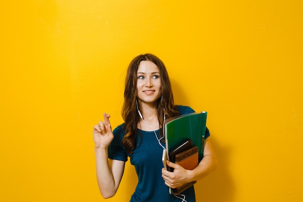 Retrato de jovem estudante linda garota segurando livros e material escolar