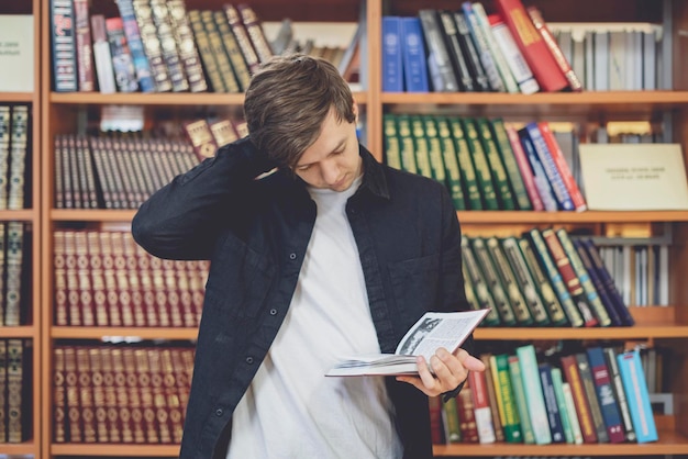 retrato de jovem estudante na frente da estante de livros na biblioteca b