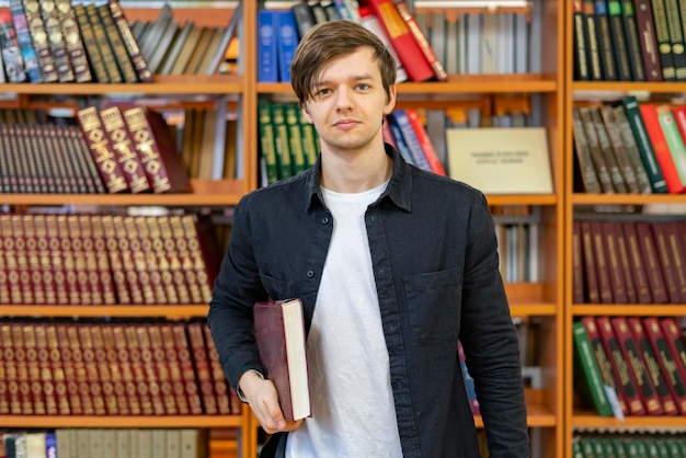 retrato de jovem estudante na frente da estante de livros na biblioteca b
