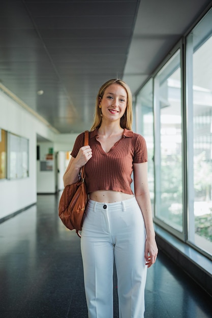 Retrato de jovem estudante sorridente olhando para a câmera Ela está na universidade