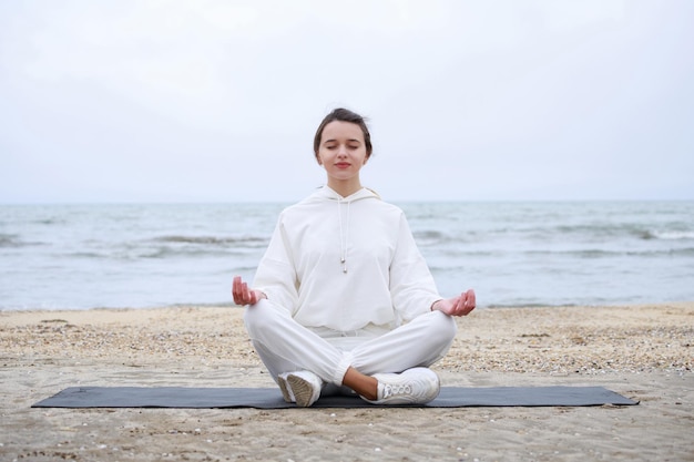 Retrato de jovem fazendo sua meditação na praia Foto de alta qualidade