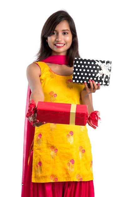 Retrato de jovem feliz sorridente indiana segurando caixas de presente em um branco.